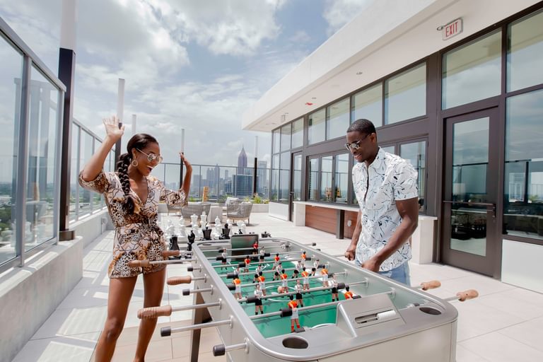 Vireo man and woman playing foosball on rooftop